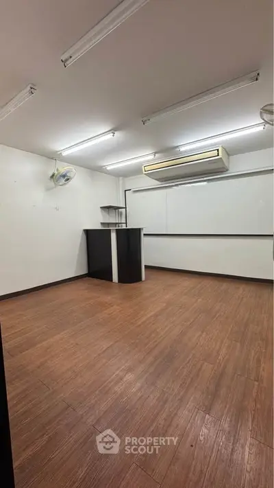 Spacious study room with wooden flooring and modern lighting