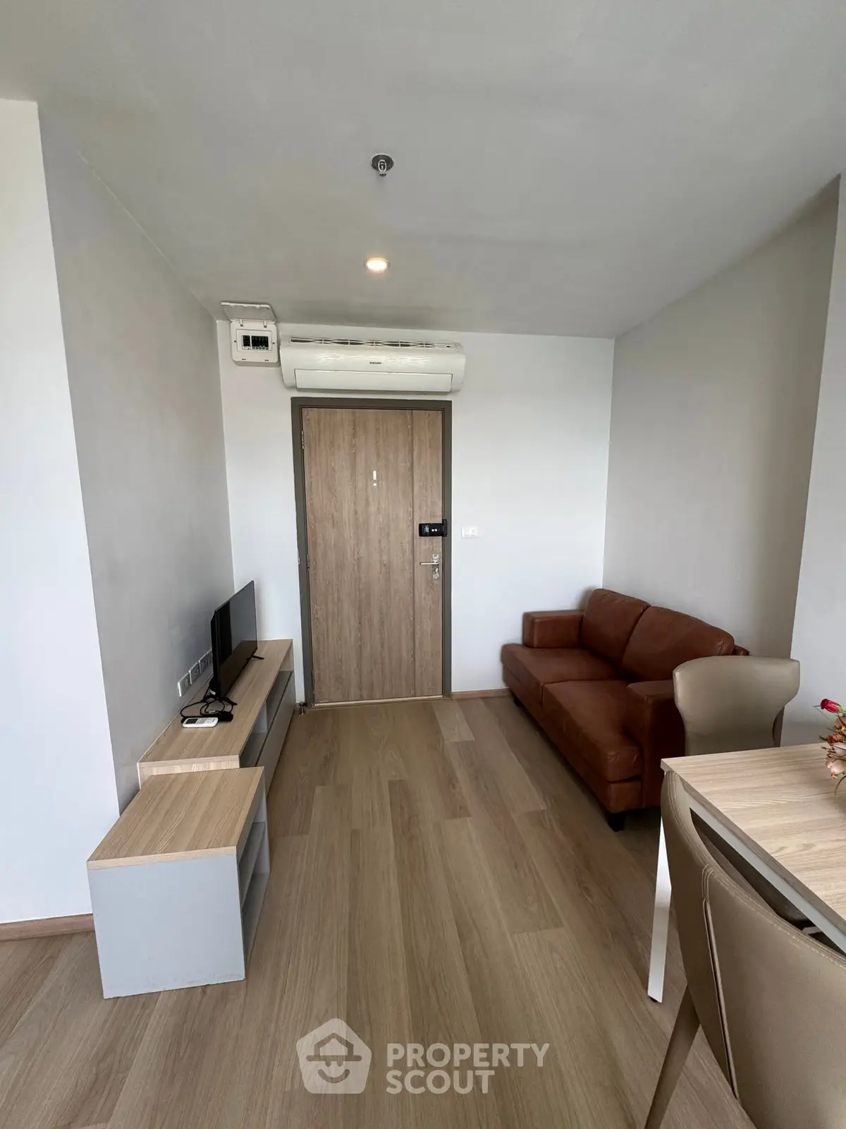 Modern living room with sleek furniture and wooden flooring in a stylish apartment.