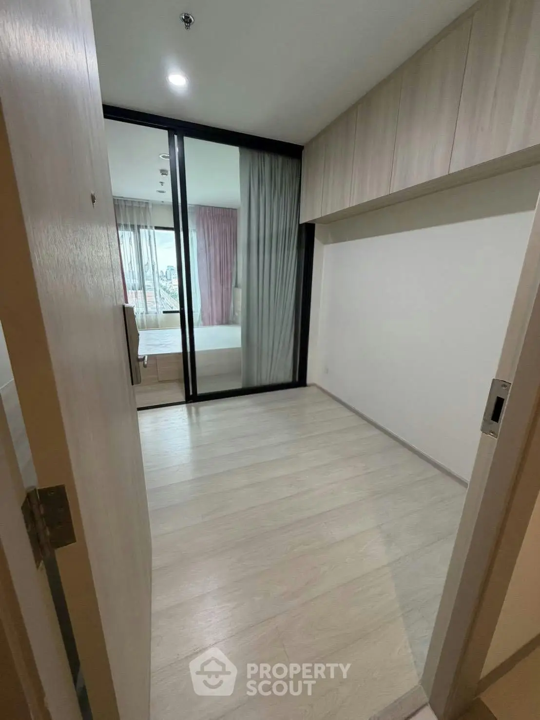 Spacious bedroom with sliding glass doors and ample natural light in modern apartment.