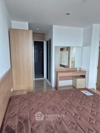 Modern bedroom with wooden furniture and stylish decor in a contemporary apartment.