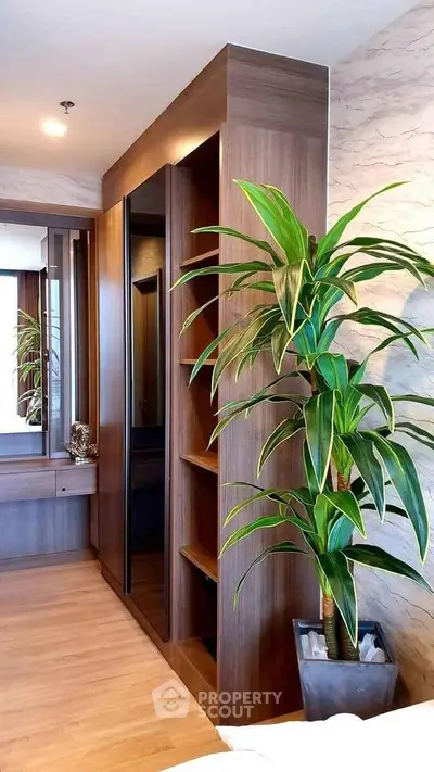 Modern bedroom with stylish wooden wardrobe and lush indoor plant
