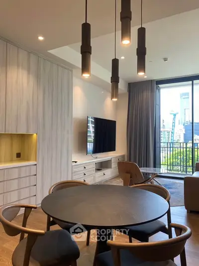 Modern living room with stylish furniture and large TV, featuring floor-to-ceiling windows with city view.