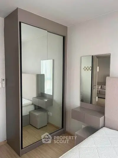 Modern bedroom with sleek mirrored wardrobe and stylish vanity set