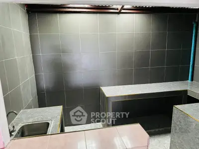 Modern kitchen with sleek black tile design and stainless steel sink