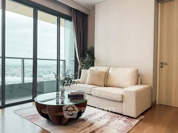 Modern living room with large windows and balcony view, featuring a cozy sofa and stylish coffee table.