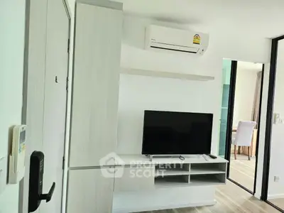 Modern living room with air conditioning and sleek TV setup in a stylish apartment.