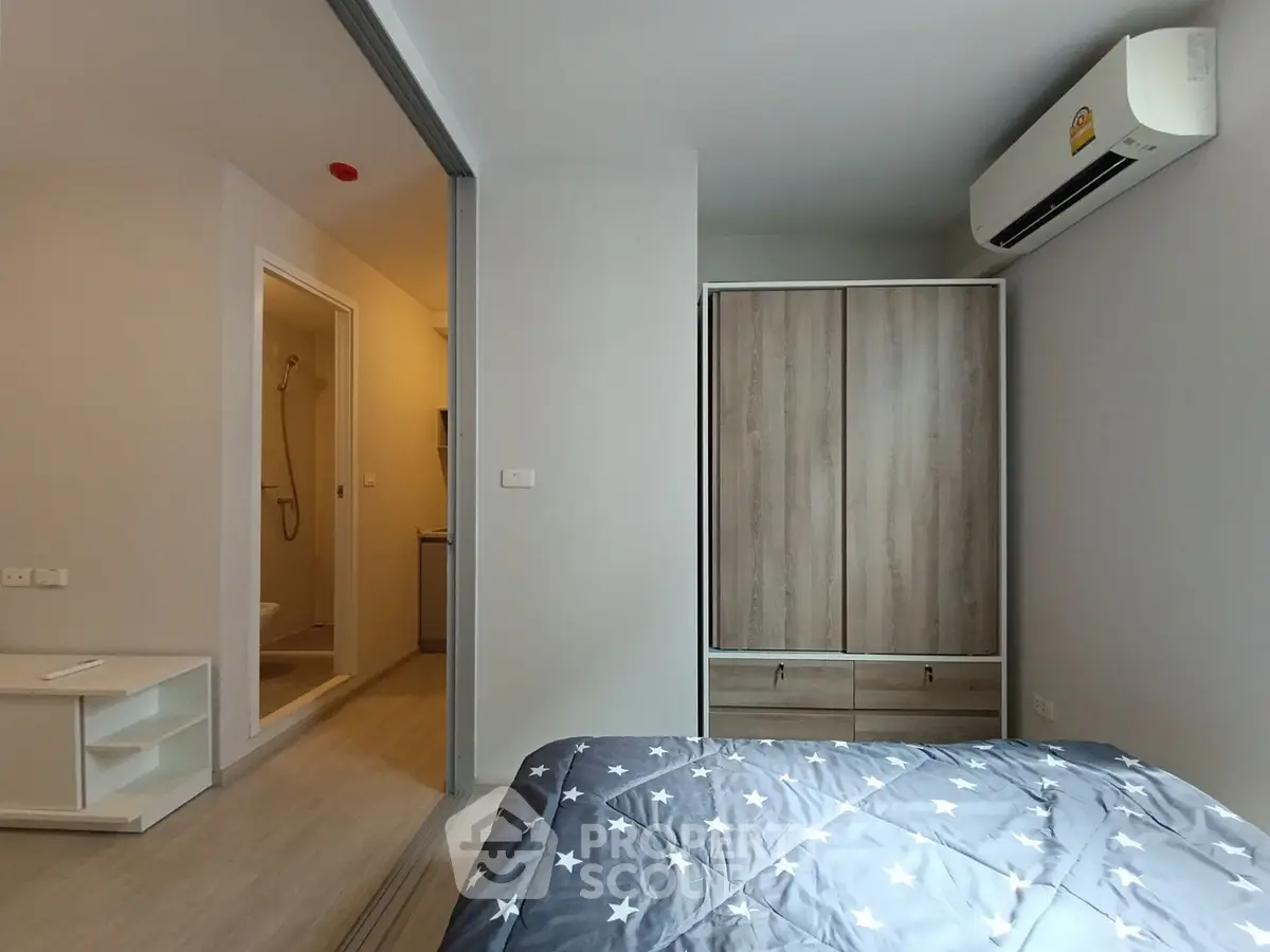 Modern bedroom with ensuite bathroom and air conditioning in a stylish apartment.