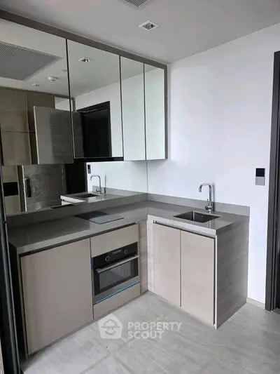 Modern kitchen with sleek cabinetry and built-in appliances in a contemporary apartment.