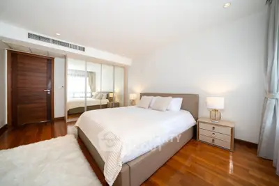 Spacious modern bedroom with wooden flooring and elegant decor