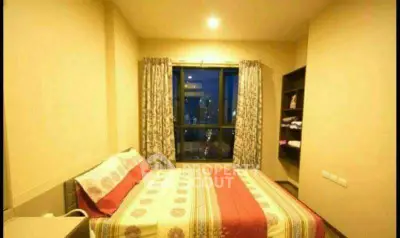 Cozy bedroom with city view, featuring a comfortable bed and elegant curtains.