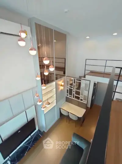 Modern loft apartment with high ceilings and stylish lighting fixtures, featuring a cozy dining area and mezzanine.