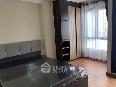 Modern bedroom with large window and stylish wardrobe in a cozy apartment.