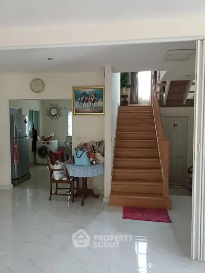 Spacious interior with elegant staircase and modern kitchen appliances, perfect for family living.