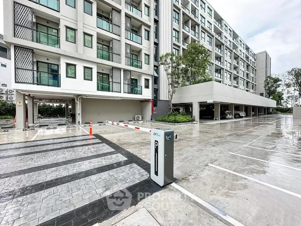 Modern apartment building with spacious parking area and sleek design.