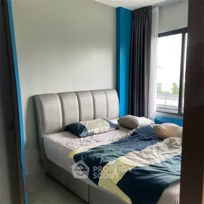 Cozy bedroom with modern decor and large window for natural light