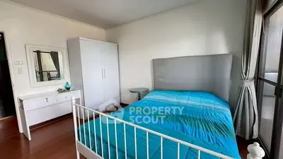 Spacious bedroom with modern decor and large window for natural light.