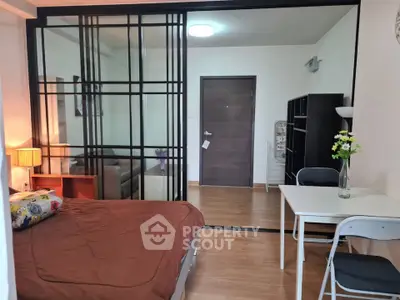 Modern studio apartment with cozy bedroom and stylish sliding glass partition.