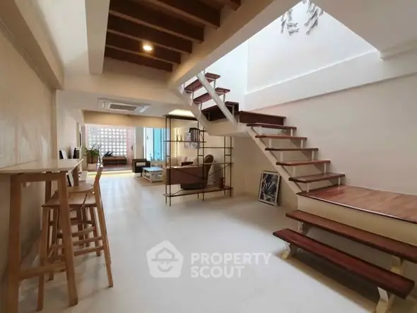 Spacious modern living room with stylish staircase and open layout, perfect for contemporary living.