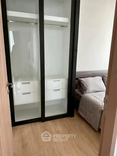 Cozy bedroom with modern wardrobe and wooden flooring