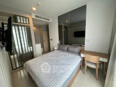 Modern bedroom with stylish decor and large mirror, featuring a cozy bed and sleek furniture.