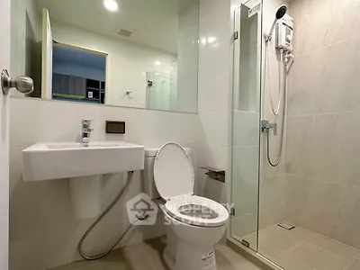 Modern bathroom with glass shower and sleek fixtures in contemporary apartment.