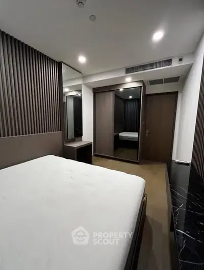 Modern bedroom with sleek design and mirrored wardrobe