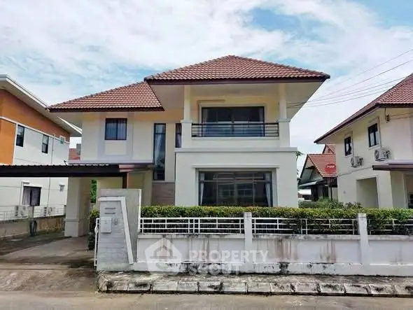 Charming two-story house with red-tiled roof and modern facade in a suburban neighborhood.