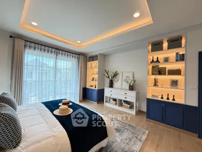 Luxurious bedroom with elegant decor and built-in shelving, featuring large windows and stylish lighting.