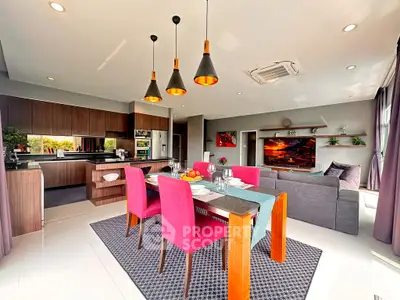Modern open-plan living room and kitchen with vibrant decor and stylish lighting.