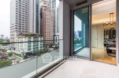 Modern apartment balcony with city view and glass railing, adjacent to elegant dining area.