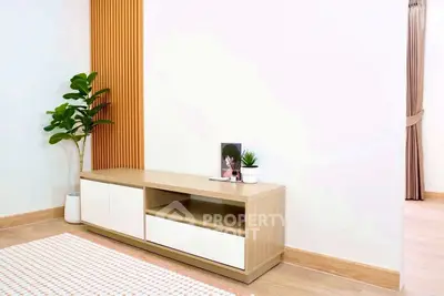 Modern minimalist living room with sleek wooden furniture and indoor plants.