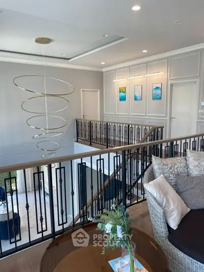 Elegant modern living space with stylish spiral chandelier and cozy seating area.