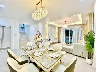 Luxurious open-plan living and dining area with elegant decor and chandelier lighting