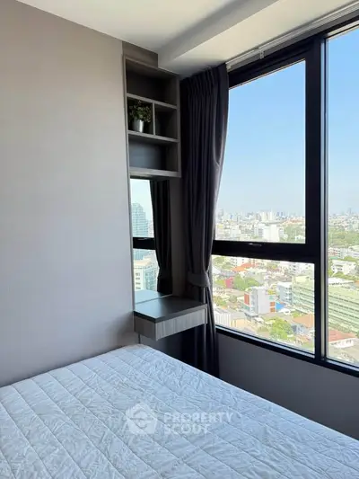 Modern bedroom with large window offering stunning city view, featuring sleek built-in shelves and cozy bedding.