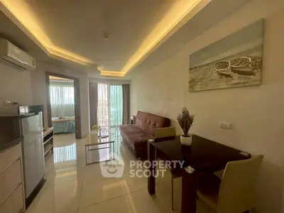 Modern living room with sleek furniture and ambient lighting, leading to a cozy bedroom with natural light.