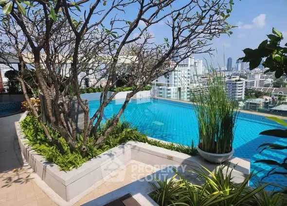 Stunning rooftop pool with panoramic city views and lush greenery.