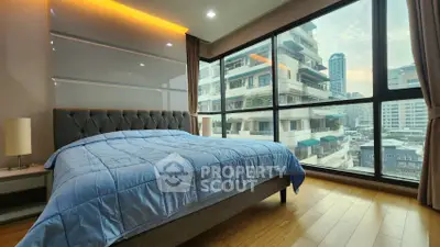 Modern bedroom with large windows offering stunning city views