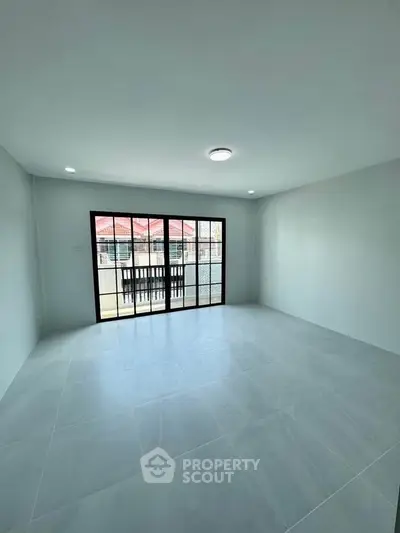 Spacious empty room with large windows and tiled flooring, perfect for customization.