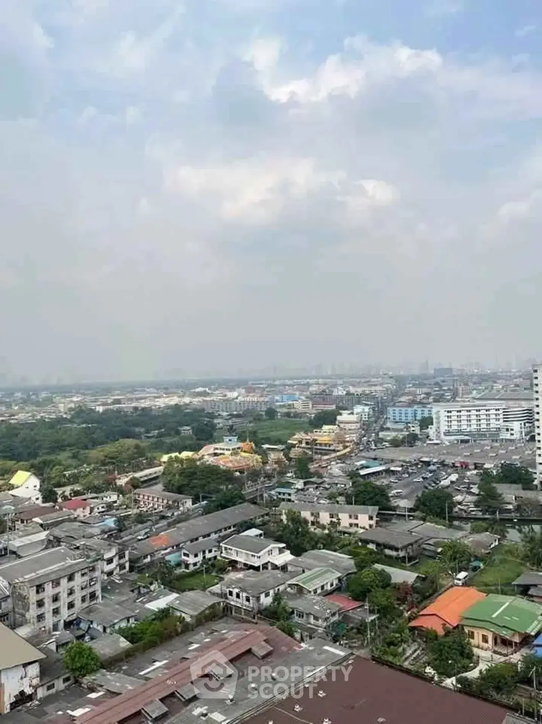 Stunning aerial view of urban landscape with sprawling cityscape and lush greenery, perfect for real estate investment.