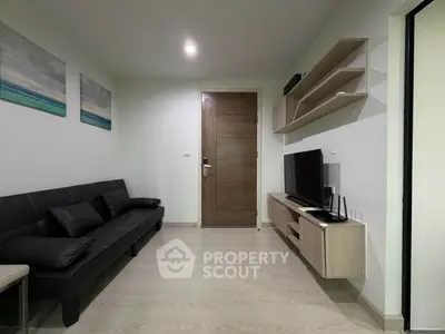 Modern living room with sleek furniture and wall-mounted TV, showcasing minimalist design and cozy ambiance.