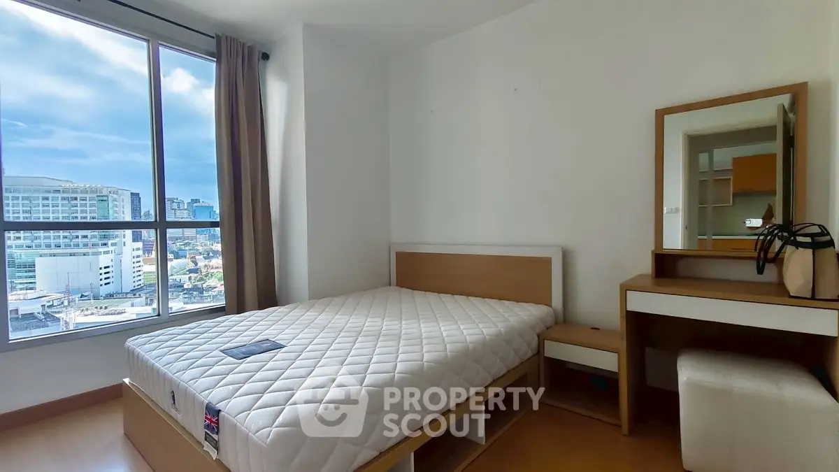 Modern bedroom with city view, featuring a cozy bed and stylish vanity set.