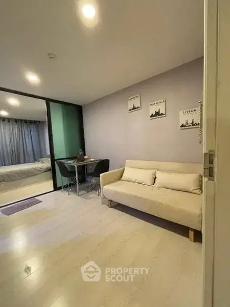 Modern living room with cozy sofa and dining area in open-plan apartment.