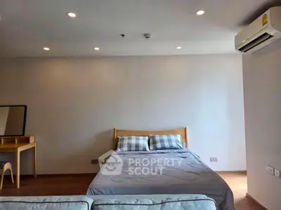 Spacious bedroom with modern decor and air conditioning in a stylish apartment.