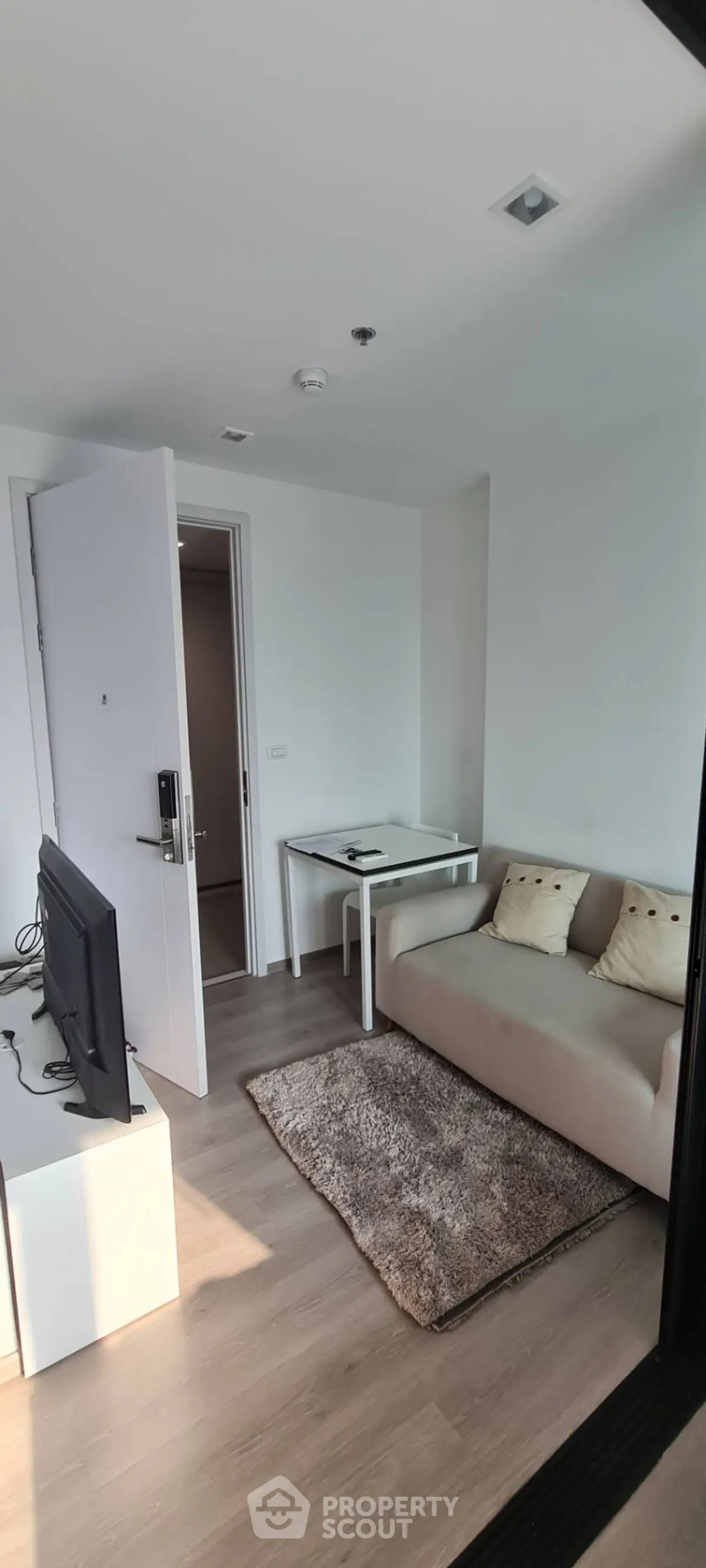 Modern living room with cozy sofa and TV setup in a bright apartment.