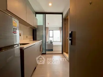 Modern kitchen with sleek design and open layout leading to living room