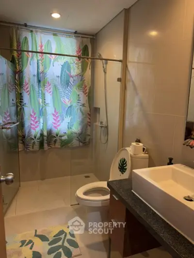 Modern bathroom with glass shower and tropical-themed decor