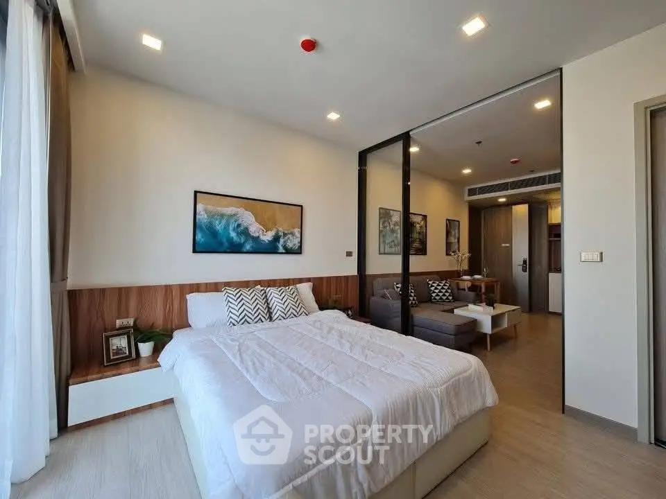 Modern bedroom with stylish decor and cozy living area in open layout apartment.