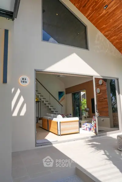 Modern open-concept living room with high ceilings and stylish staircase