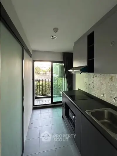 Modern compact kitchen with sleek design and balcony view