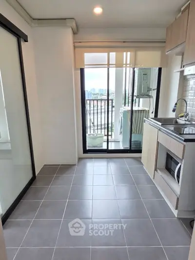 Modern kitchen with balcony view and sleek tile flooring